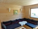 Wohnbereich - Couch und Wandverkleidung aus Holz